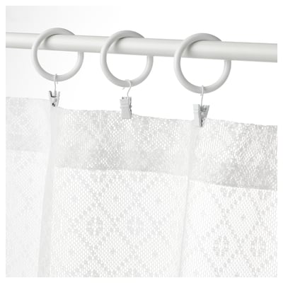 White marilela curtains with a circular metal rod and clips.