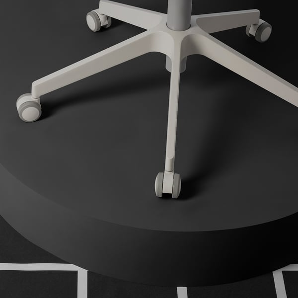 Close-up of a high-quality office chairs sturdy, adjustable base with smooth-rolling casters on dark floor.