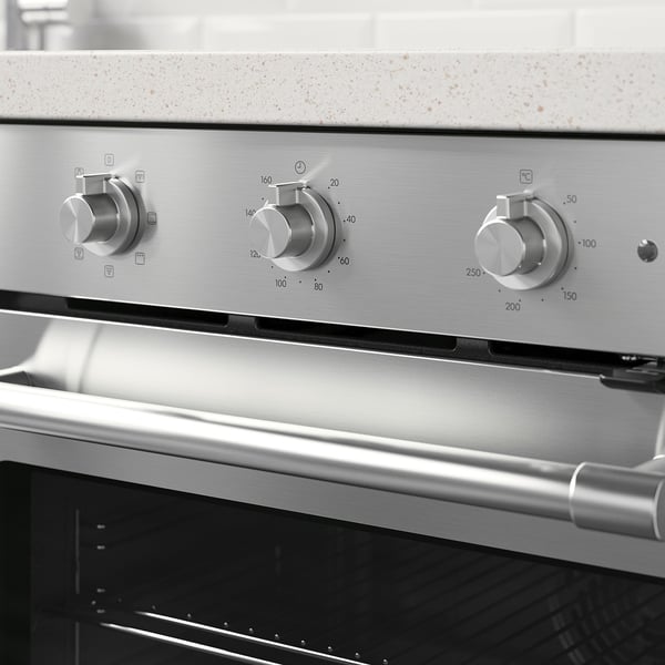 Stainless steel oven knobs set for temperature control, indicating cooking modes and times.