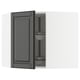 A gray ikea METOD kitchen cabinet with a black beveled edge door and an adjustable glass shelf.