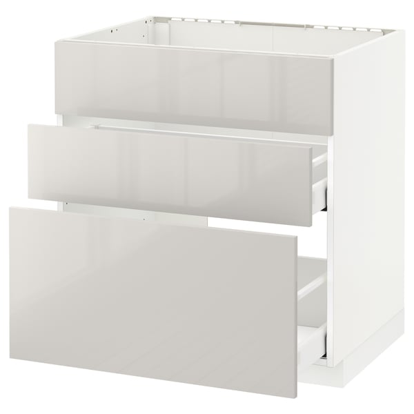 Modern kitchen: white METOD cabinet with glossy drawers. Three open drawers, sleek design.