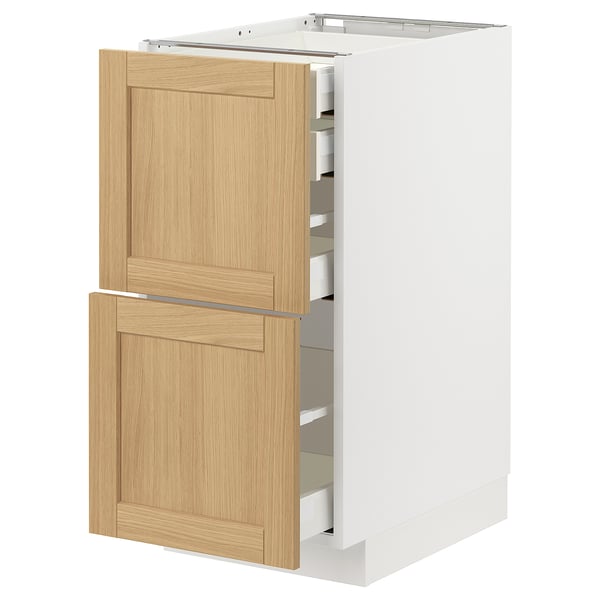 Depicts an open white kitchen cabinet with light wooden drawers featuring a classic design.