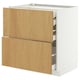 A METOD kitchen cabinet in white and light wood. It has both drawers and shelves.