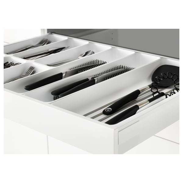 Open kitchen drawer with cutlery and utensils organised in compartments.