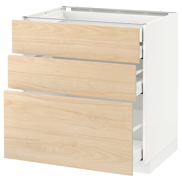 A white METOD kitchen cabinet with three light ash wood drawers, featuring sleek and modern design.