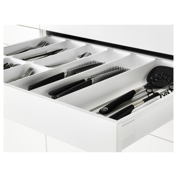 White kitchen drawer organiser with black handles, holding various utensils.