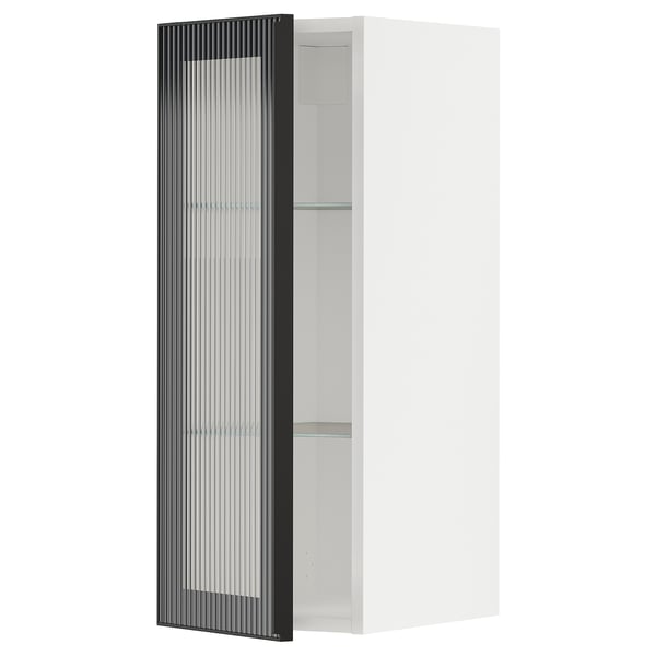 A white METOD wall cabinet from ikea with a black hejsta glass door featuring a metal frame and reeded glass.