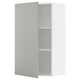 A white METOD kitchen cabinet with a grey door in a modern design. It two shelves inside.