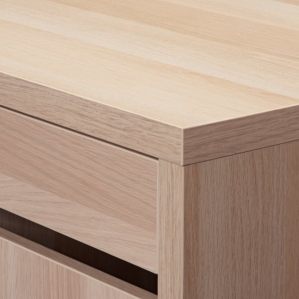 Close-up of sleek, modern wooden desk; light tone, smooth finish, sturdy joinery.