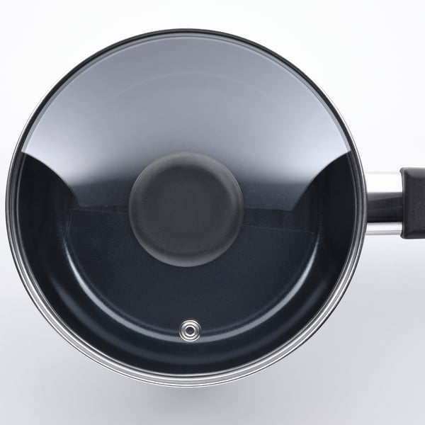 Saucepan with glass lid, non-stick coating, stainless steel base, sturdy handle.