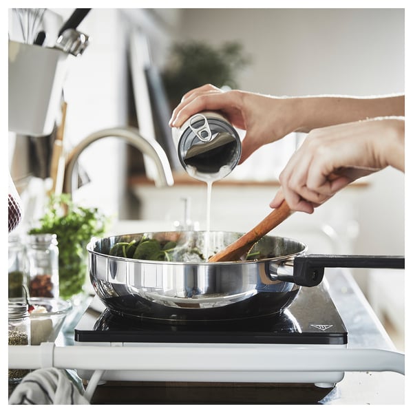 Seasoning food in silver pan with lid.