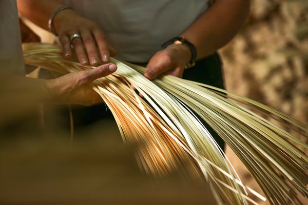 Hands crafting woven bamboo, creating unique, eco-friendly MISTERHULT lamp.
