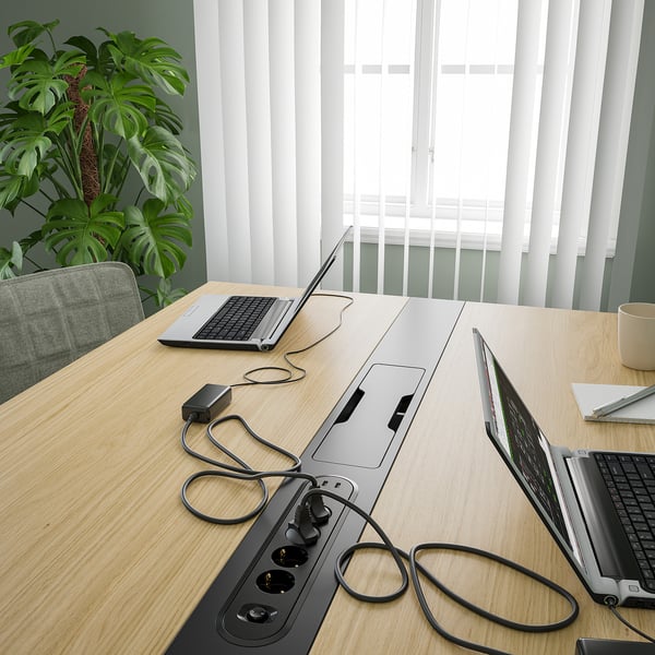 Conference table with built-in power modules and cable management, ideal for meetings or work spaces.