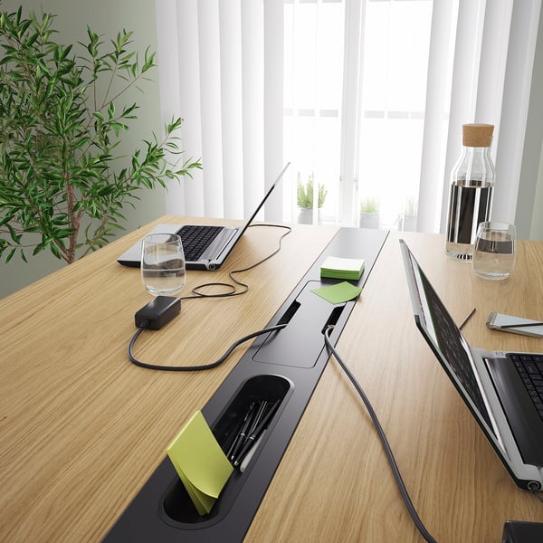 Modern conference table with cable management and power sockets. Sleek, wooden surface and built-in pen holders for organised meetings.