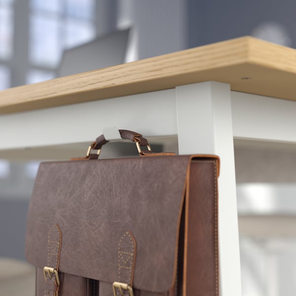 Brown leather bag hangs on wooden and metal shelf.