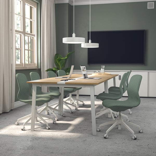 Conference room with MITTZON tables and långfjäll chairs, green walls, tv, and large windows.