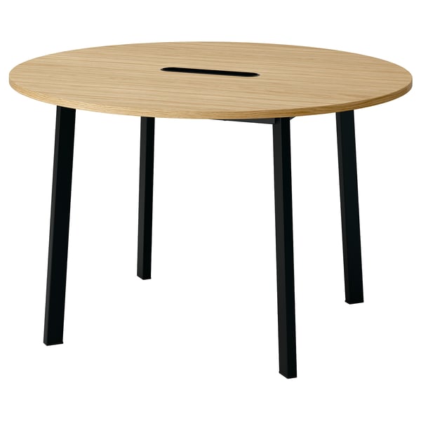 A round, wooden conference table named MITTZON with four black legs. It has a sleek design and includes cable management.