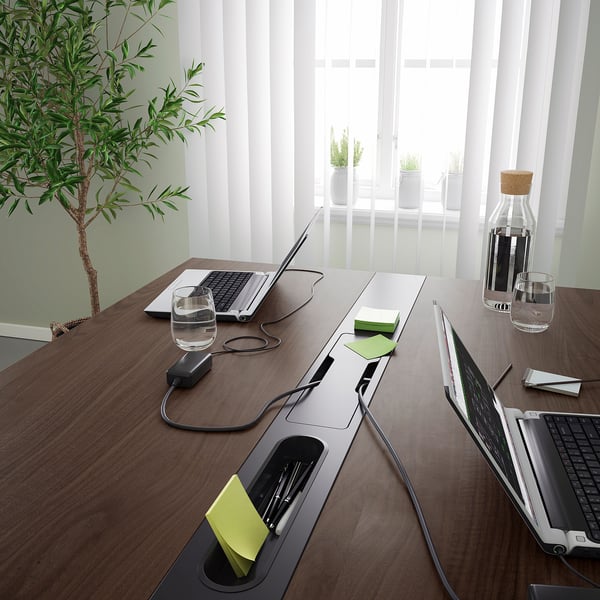 Modern conference table with built-in power modules and clever cable management, perfect for meetings and co-working spaces.