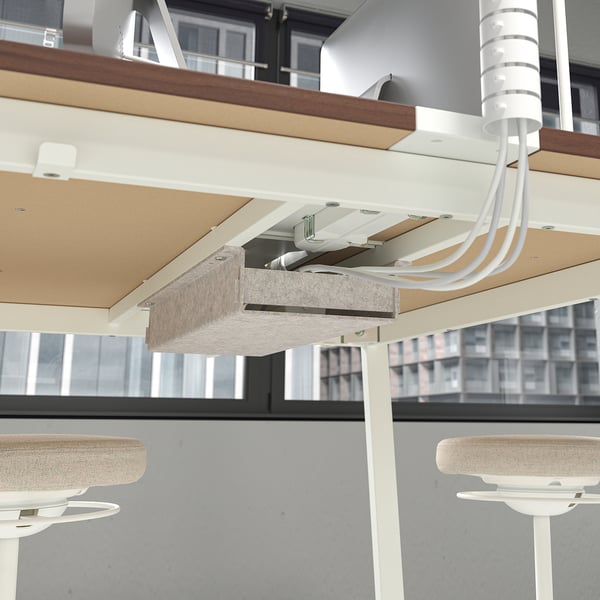 Under-table cable management system with footrests for comfort and support in office setting.