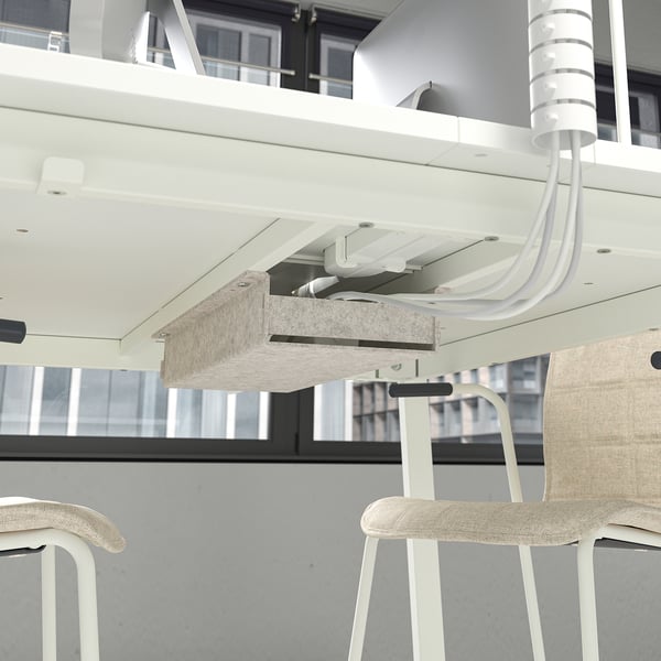 Under-desk footrest attached to high table with adjustable stool; cable management visible.