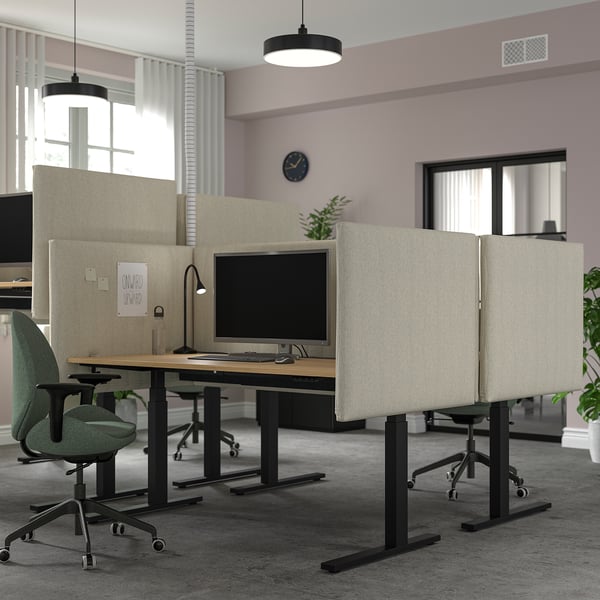 Modern office with MITTZON desks, light desks, green chairs, beige partitions, hanging lights, and wall clock.