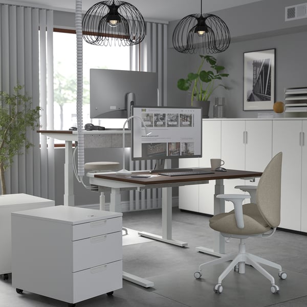 Modern home office: MITTZON white sit-stand desk, ergonomic chair, dual monitors, sleek decor. Desk large, chair small.