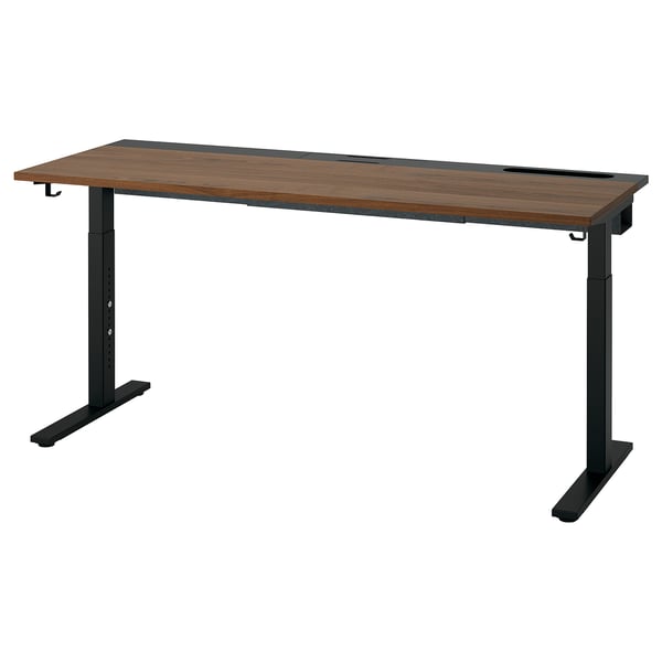 The MITTZON desk a rectangular wooden top with a brown finish and black metal legs, designed for height adjustment and cable management.