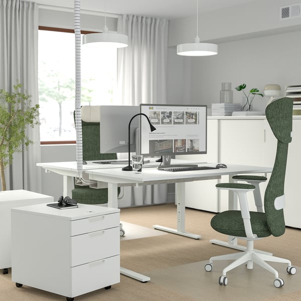 Home office: MITTZON desk, ergonomic chair, monitor, keyboard, mouse, lamp, file cabinet, curtains.