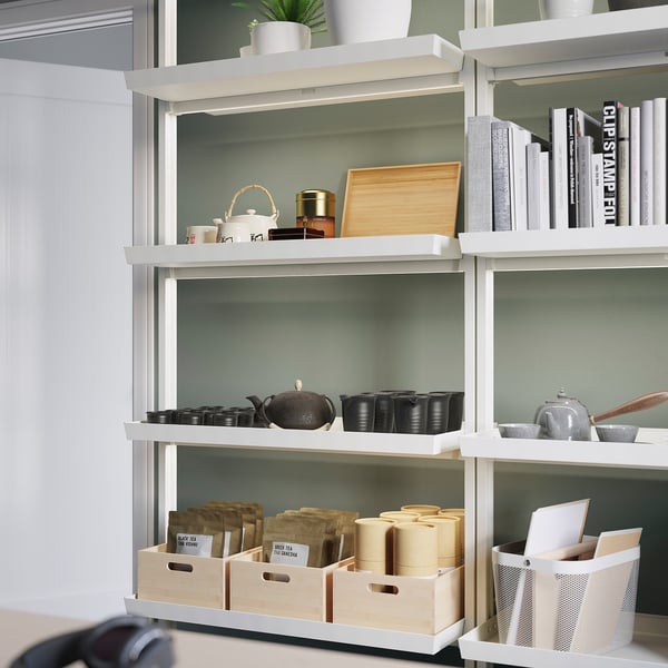 Modern MITTZON office shelf with adjustable sections holding supplies, books, decor, laptop, and boxes.