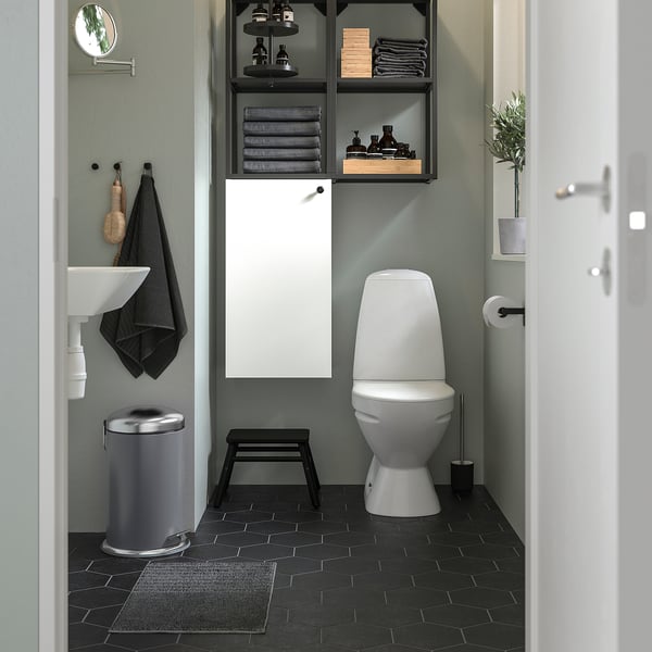 Modern grey bin in bathroom with toilet, sink, and black accents.