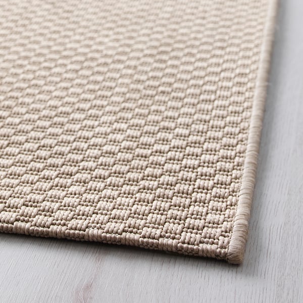 Light beige woven rug, texture close-up, quality craftsmanship evident.