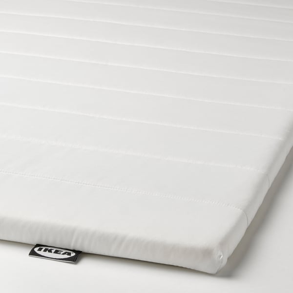 Cube-shaped white mattress topper with quilted pattern, branded ikea on tag.