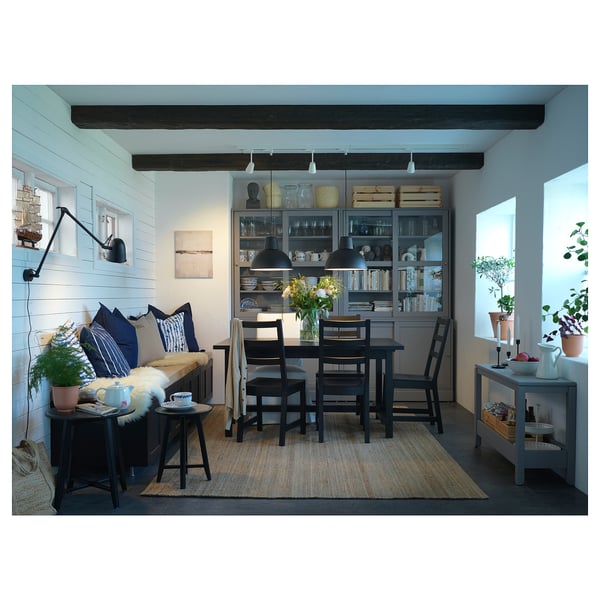 Modern dining room with NORDVIKEN table, chairs, and wooden decor. White walls, bookshelves, and floral accents.