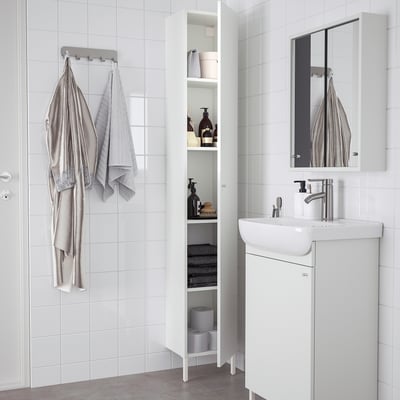 Modern white NYSJÖN bathroom cabinet with shelves for towels and toiletries.