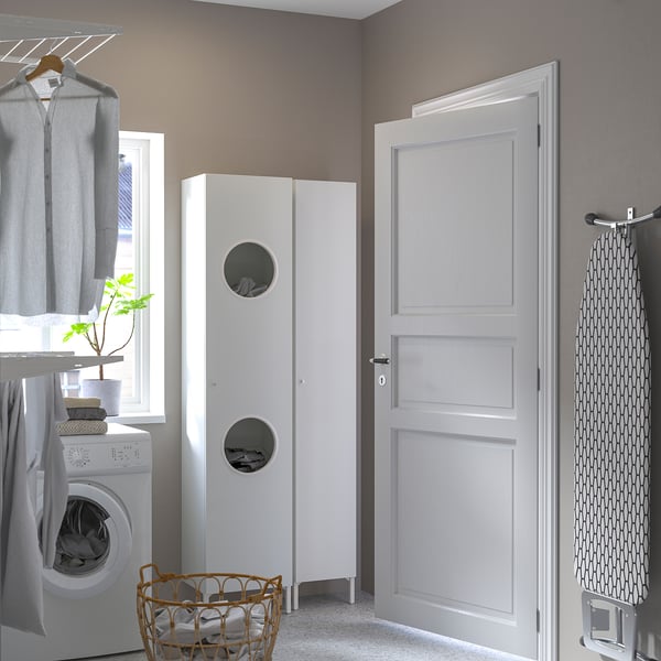 Small white NYSJÖN cabinet, round cutouts, between washing machine & door.