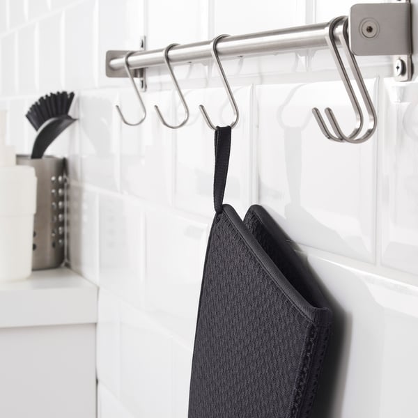 Stainless rack with hooks, holding black drying mat.