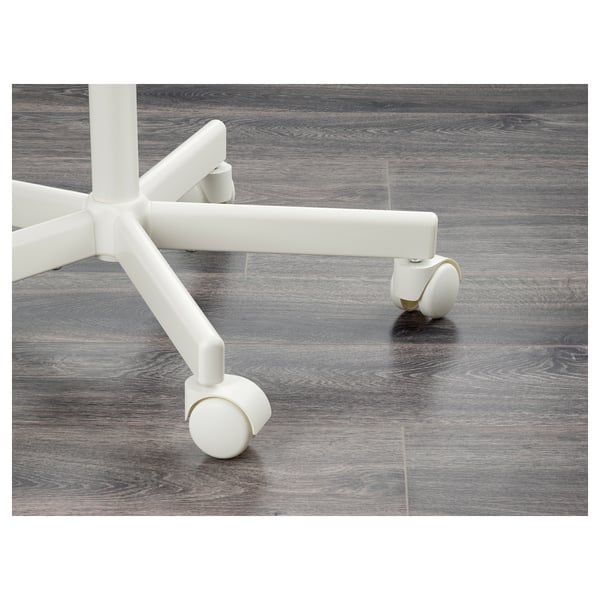 Displays a close-up of a chairs base with wheels on a wooden floor. It strong, white, metal construction and durable wheels.