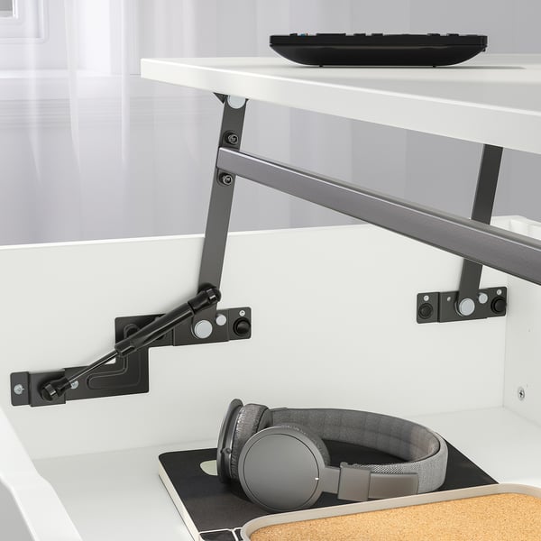 Adjustable height desk with extended keyboard tray. Headset and mousepad on shelf.
