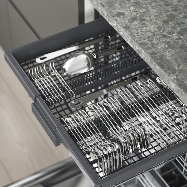 Open dishwasher with cutlery slots, holding forks, knives, spoons, and serving utensils.