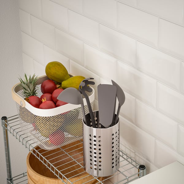 Kitchen organiser with fruit basket and utensils.