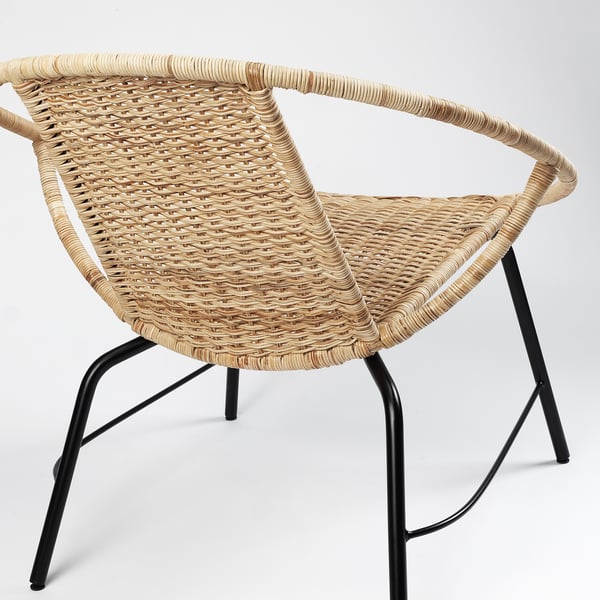 Wicker chair with black metal legs; detailed weave, sturdy frame.
