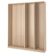 A light wood-colored ikea PAX wardrobe frame. It is tall and rectangular with adjustable feet, designed for bedroom storage.