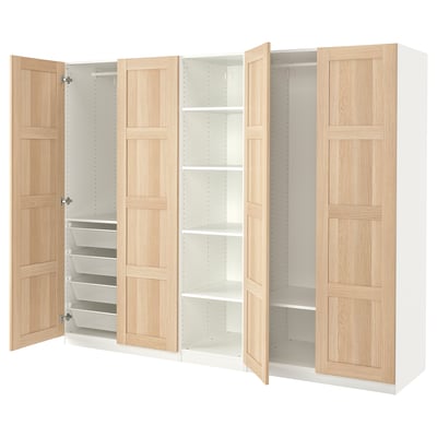 An ikea PAX wardrobe with light oak doors. It adjustable shelving and compartments, including mesh drawers for folded clothes.