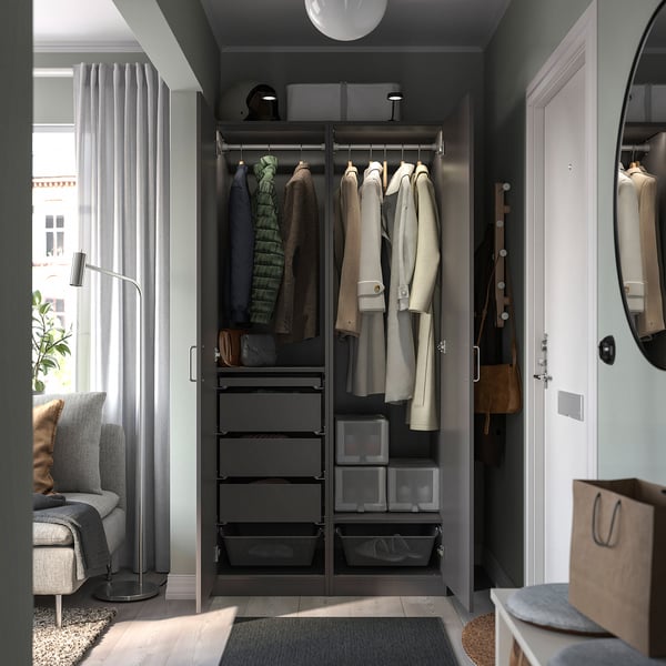 Open wardrobe PAX with black frames, drawers, and hangers holding clothes. Your image is concise, yet descriptive.