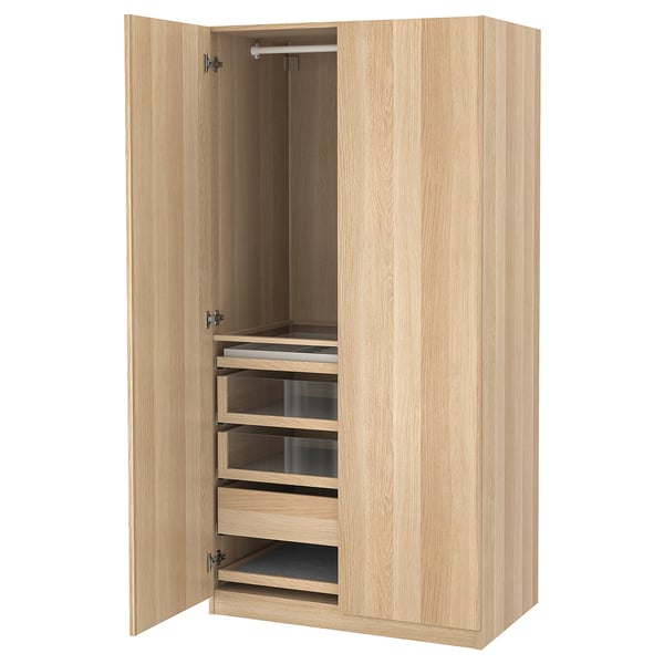 A wooden PAX wardrobe, open. It has multiple shelves and drawers, including glass-fronted ones, set in an oak finish.