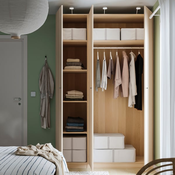 Open wardrobe with clothes, shelves, and boxes; light wood finish.