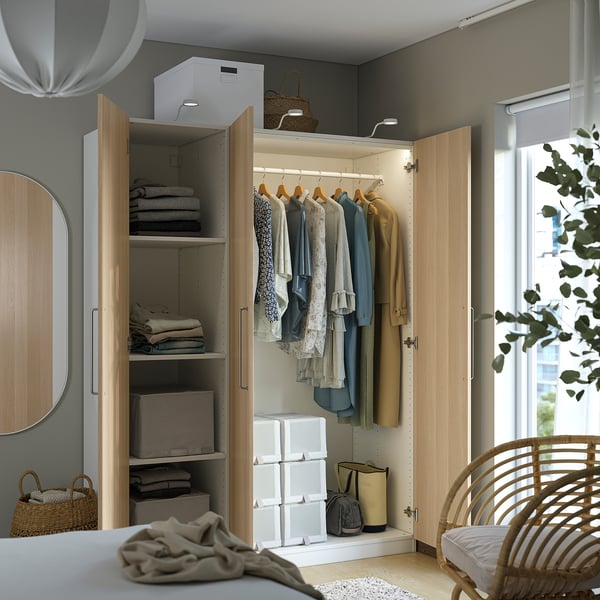 Organised wardrobe with clothes hangers, shelves, and storage bins. Integrated lighting illuminates hanging garments.