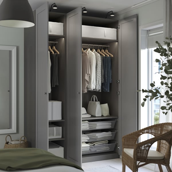 Open wardrobe with clothes, shelves, and lighting.