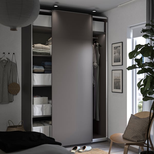 Modern grey open wardrobe, wicker chair beside.