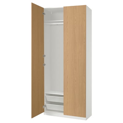 An open white and light wood-colored PAX wardrobe with shelves and drawers.
